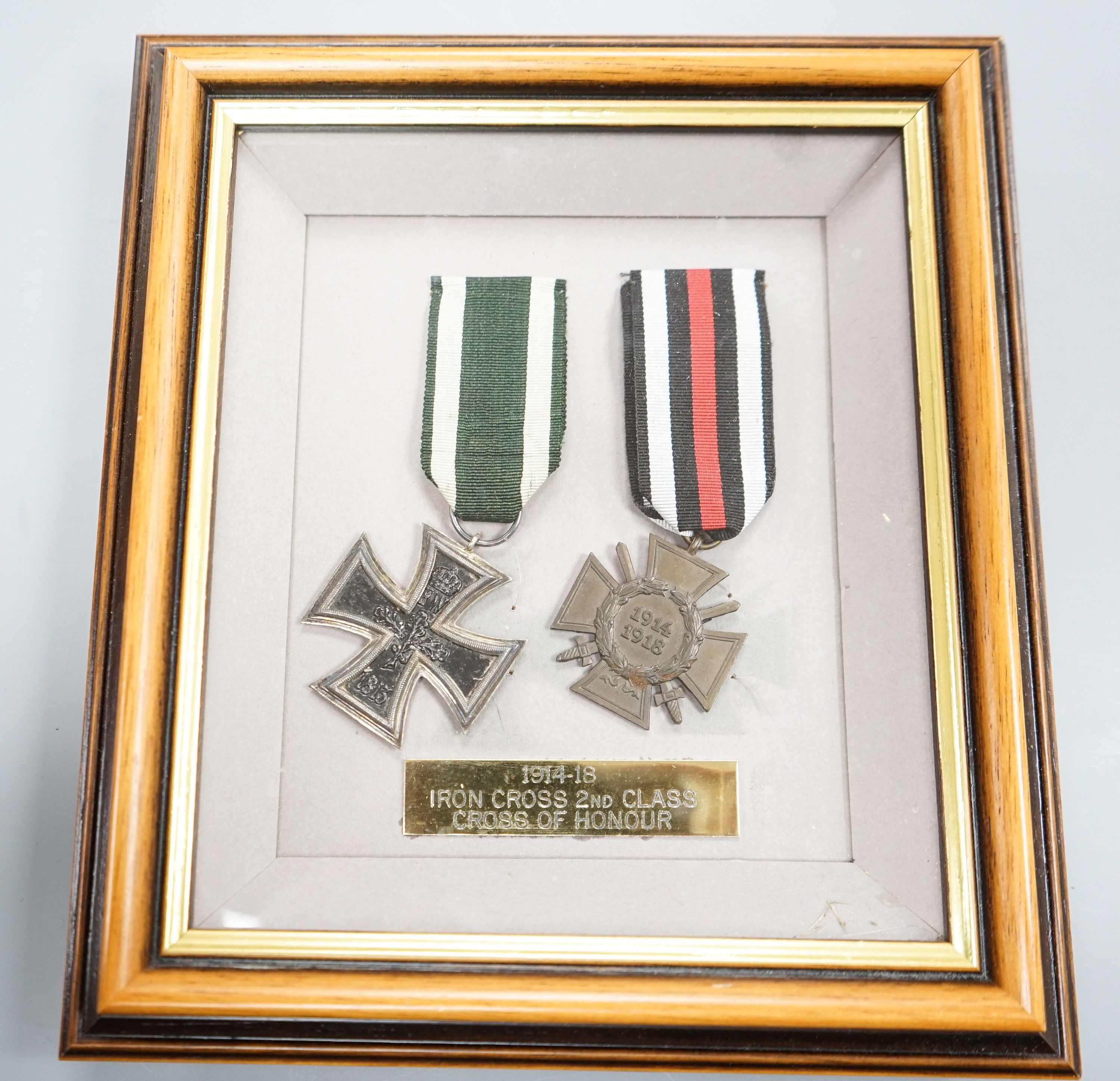 A German WWII Mother's Cross, rare unfinished, framed WWI Iron Cross and Cross of Honour and two miniature photographic booklets.